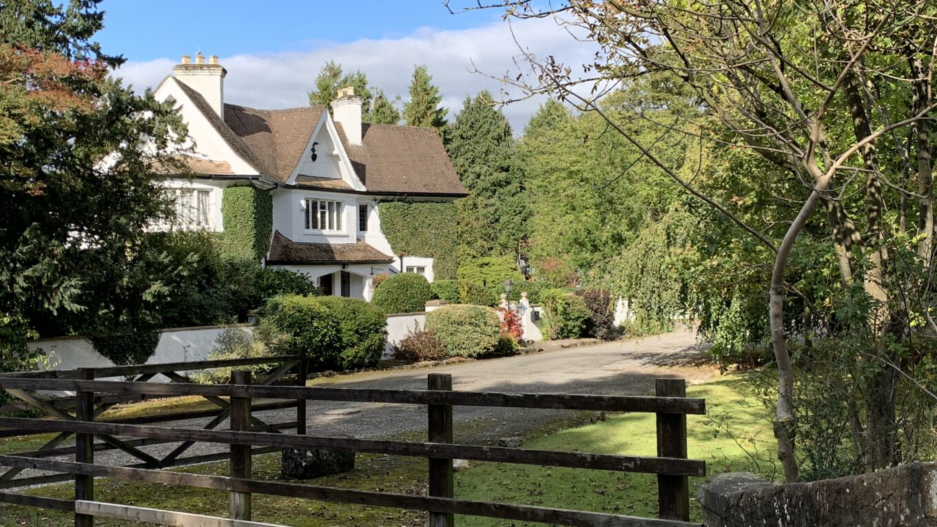 House at Croxdale next to the River Wear. The house is painted white and has extensive ivy growth on the walls. The garden is haevily planted.
