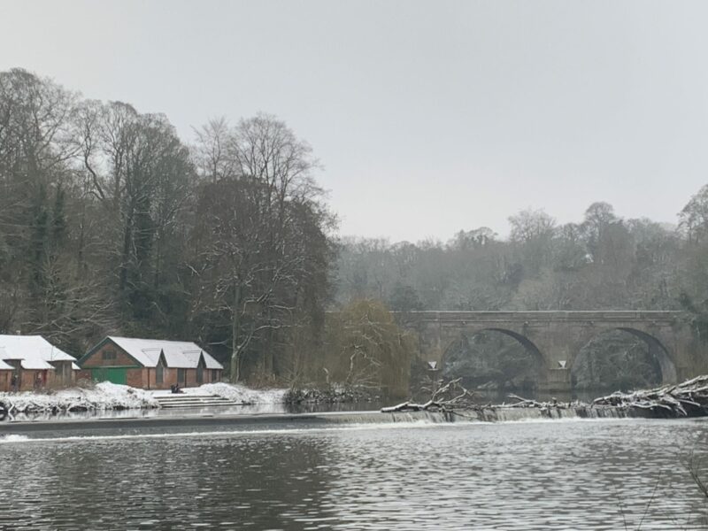 The weir, boathouses and Prebends Bridge in the snow